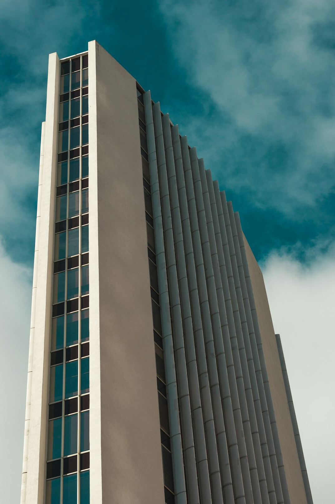 Tall glass and concrete building seen from below