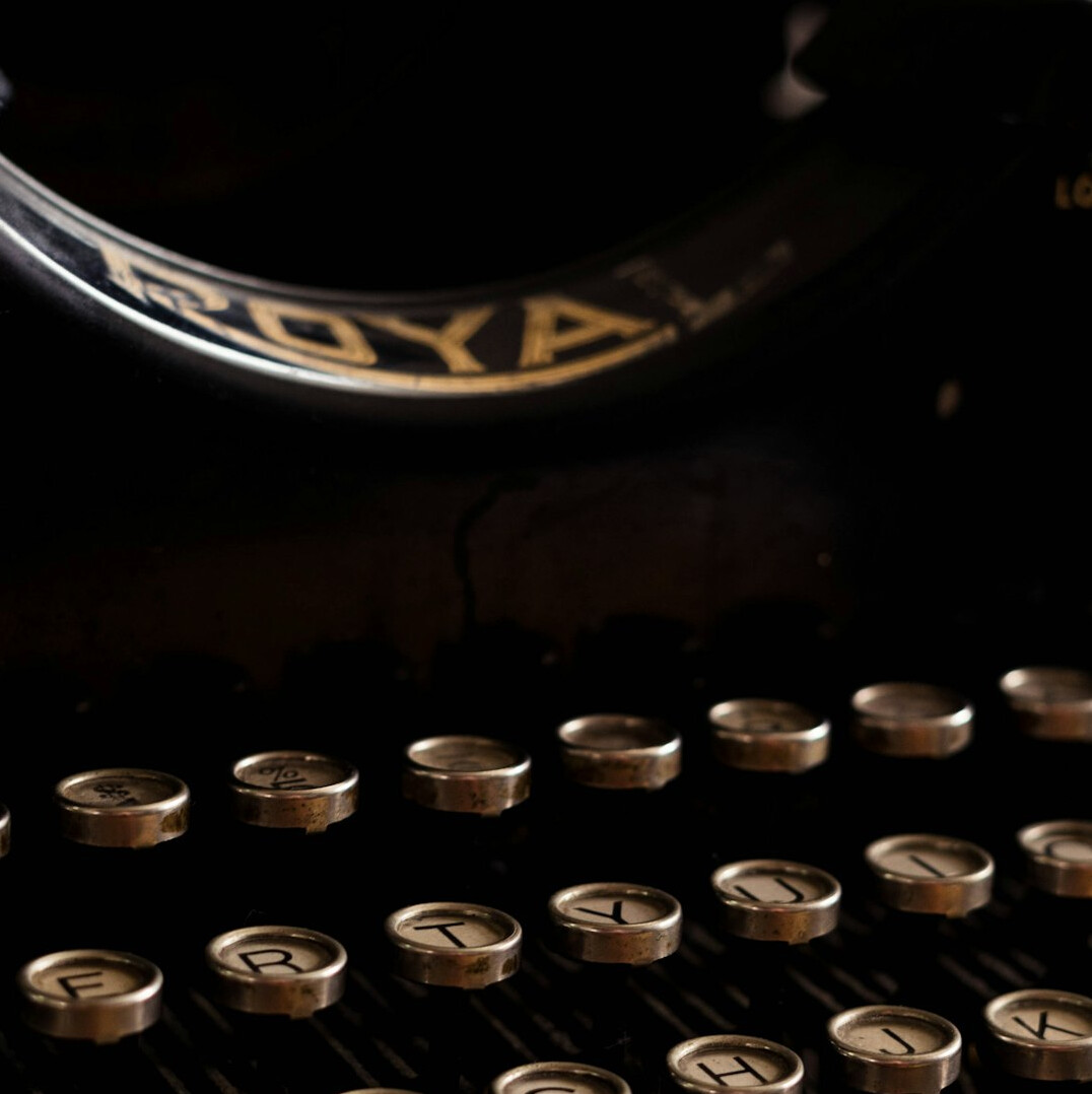 Vintage typewriter with a sheet of paper on a wooden desk